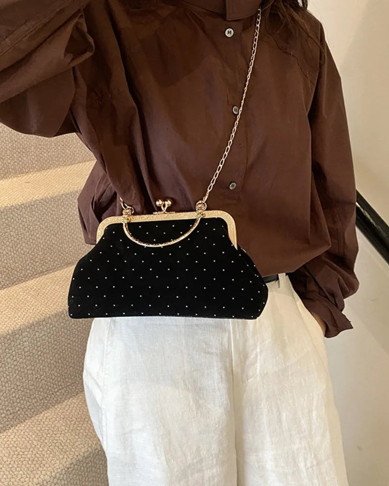 Black velvet-look evening clutch Bianca Rose worn with gold-tone chain strap.